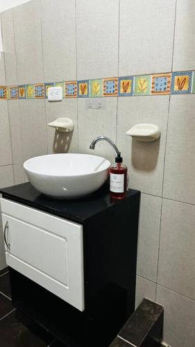 a bathroom with a bowl sink on a black counter at Alojamiento con Aire Acondicionado céntrico en Puyo in Puyo