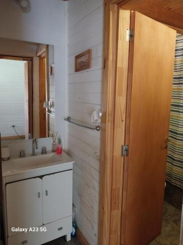 La salle de bains est pourvue d'un lavabo et d'un miroir. dans l'établissement Antares, à Villa La Angostura