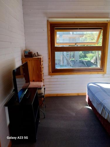 - une chambre avec un lit, un bureau et une fenêtre dans l'établissement Antares, à Villa La Angostura