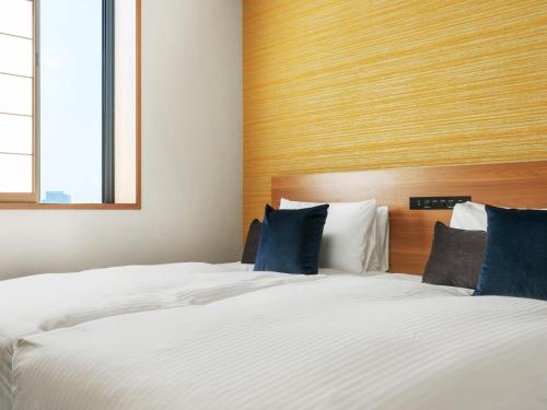 - une chambre avec 2 lits dotés d'oreillers bleus dans l'établissement MIMARU TOKYO ASAKUSA STATION, à Tokyo