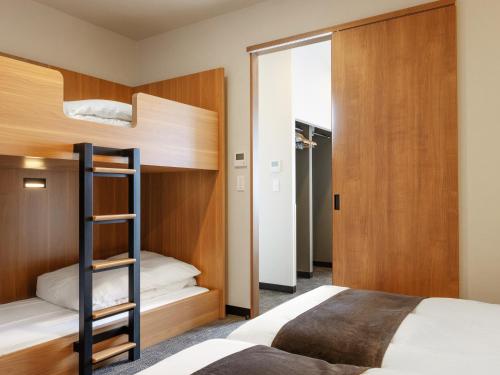 1 dormitorio con 2 literas y escalera en MIMARU TOKYO ASAKUSA STATION, en Tokio