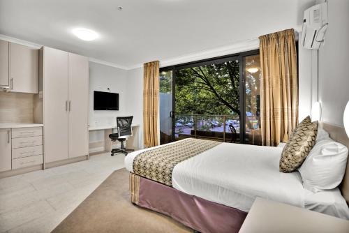 a bedroom with a bed and a large window at Carlton Lygon Lodge - Close to Melbourne Uni in Melbourne