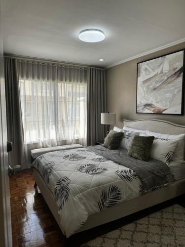 a bedroom with a large bed and a window at Bonel Townhouse Tagaytay in Alfonso