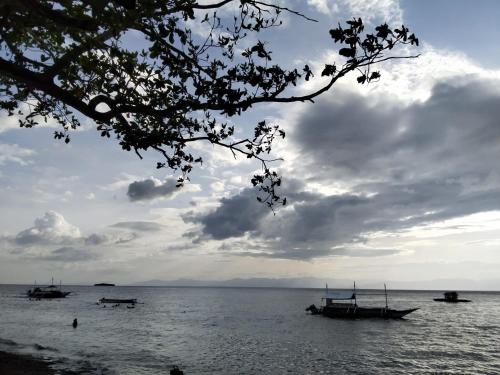 a group of boats in the water under a cloudy sky at Moalboal Beach Front Hotel in Moalboal