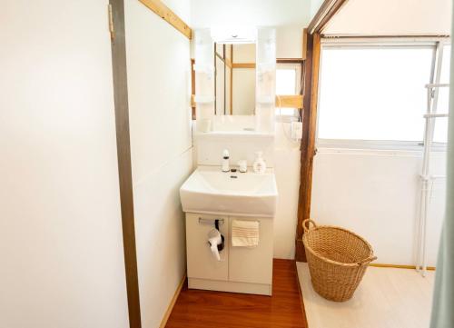 uma casa de banho com um lavatório e um espelho em かぐら庵 em Kitakata