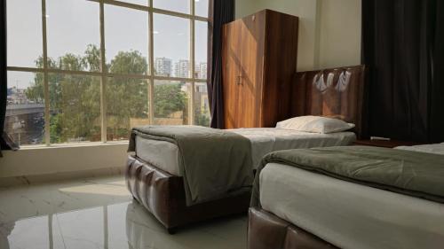 a bedroom with two beds and a large window at 1BH with Pantry in Hyderabad