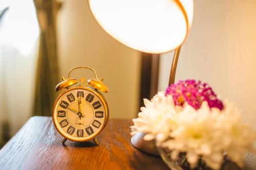 a clock sitting on a table next to a lamp at Karlhof in Sebeş