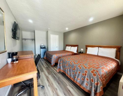 a hotel room with two beds and a desk at Villa Court Inn Oroville in Oroville