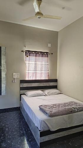 Schlafzimmer mit einem großen Bett und einem Fenster in der Unterkunft Leo home stay in Hampi