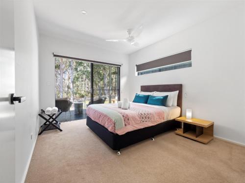 a bedroom with a bed and a large window at Tall Trees Margaret River in Margaret River Town