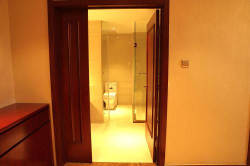 a bathroom with a toilet and a glass doorway at Wo Er Si Hotel in Fusong