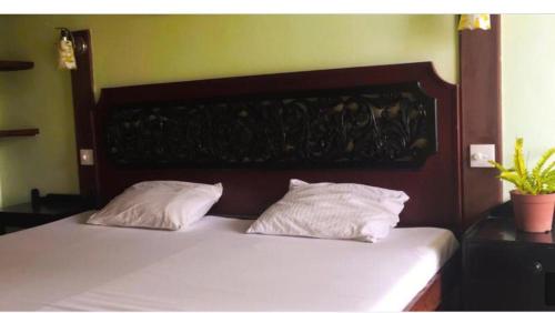 Una cama con dos almohadas encima. en S and P apartments, en Negombo