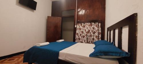 a bedroom with a bed with a blue blanket at Hotel Sansivar in El Venado