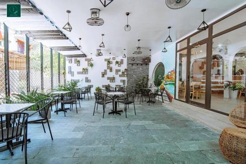 ein Restaurant mit Tischen und Stühlen in einem Zimmer in der Unterkunft SAMI Coffee Hotel in Dong Hoi