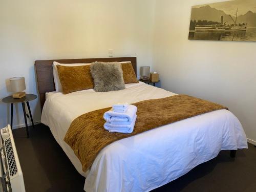 a bedroom with a bed with towels on it at Glenorchy Retreat Apartment in Glenorchy