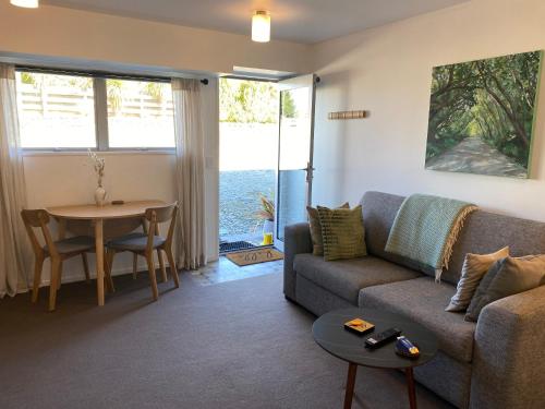 a living room with a couch and a table at Glenorchy Retreat Apartment in Glenorchy