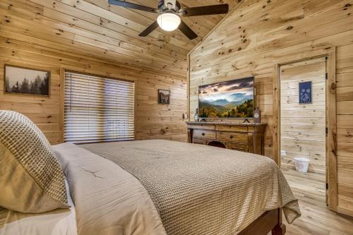 ein Schlafzimmer mit einem Bett in einer Holzhütte in der Unterkunft Kitt's Cottage, Pickleball Court, Creek, WIFI, Mountain Views, Starting at 79" in Cosby
