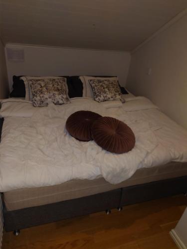 Una cama con dos almohadas marrones encima. en Molgans Boning, en Vadstena