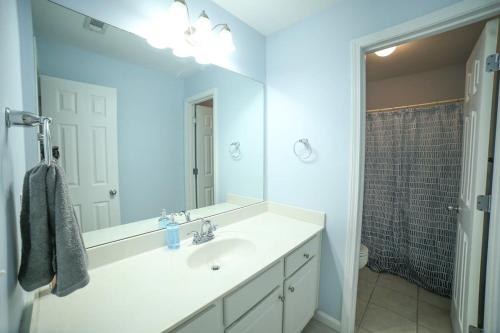a white bathroom with a sink and a mirror at Big 5 Bdrm Private Hot Tub Pool Table Near Shops in Loganville