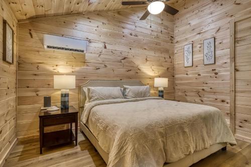 een slaapkamer met een bed en een houten muur bij Misty Cove Cabin in Cosby