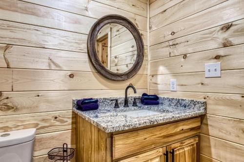 een badkamer met een wastafel en een spiegel bij Misty Cove Cabin in Cosby