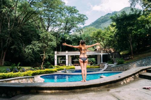 a woman in a bikini standing in a swimming pool at Hotel Kopal in Lanquín