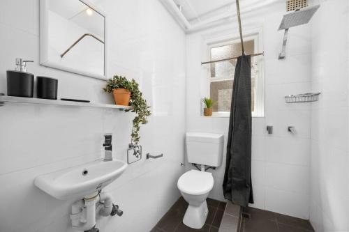 a white bathroom with a sink and a toilet at Urban retreat in Potts Point in Sydney