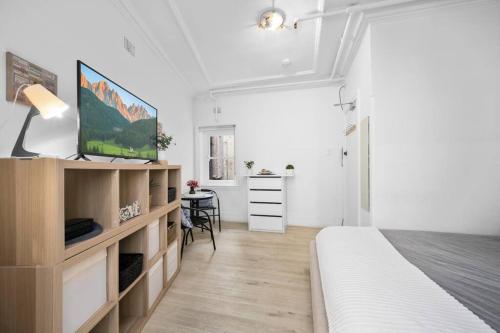 a white bedroom with a bed and a desk at Urban retreat in Potts Point in Sydney