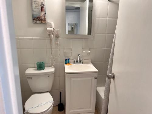 a bathroom with a toilet and a sink and a mirror at Ocean Front Units at Miami Beach in Miami Beach