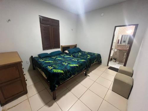a bedroom with a bed and a table and a mirror at Casa Sítio Beija Flor in Guaramiranga