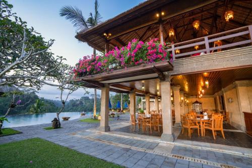 un ristorante con patio arredato con tavoli e fiori di Puri Wulandari A Boutique Resort & Spa - CHSE Certified ad Ubud