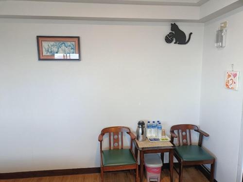 a dining room table with two chairs and a table with at Bokelai B&B in Renai