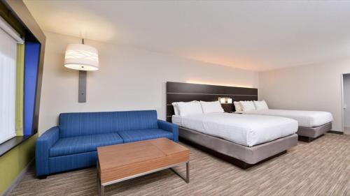 Parish-Morris SubdivisionにあるHoliday Inn Express & Suites - Parkersburg East, an IHG Hotelのベッドとソファ付きのホテルルーム