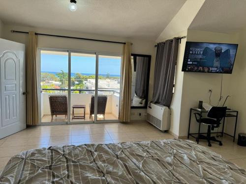 a bedroom with a bed and a view of a balcony at El más completo, a menos de 5 minutos de la playa, free wifi fuera del alojamiento in San Felipe de Puerto Plata