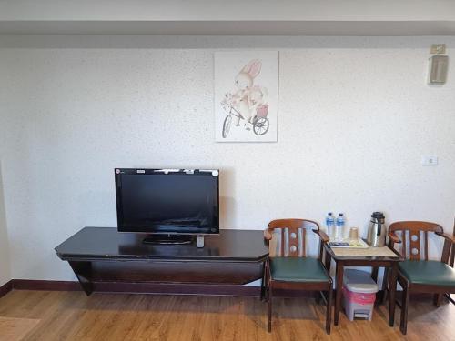 a living room with a tv and a table with chairs at Bokelai B&B in Renai