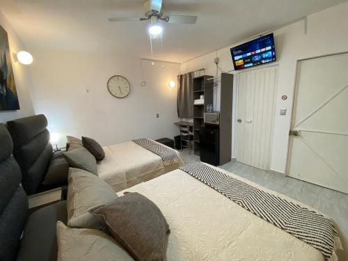 um quarto de hotel com duas camas e uma televisão em Hotel Posada Jardín Aguascalientes em Aguascalientes