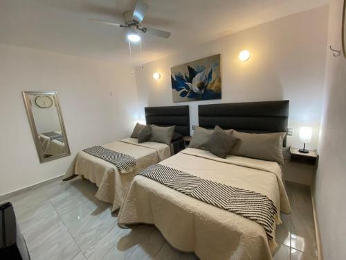 a bedroom with two beds and a ceiling fan at Hotel Posada Jardín Aguascalientes in Aguascalientes