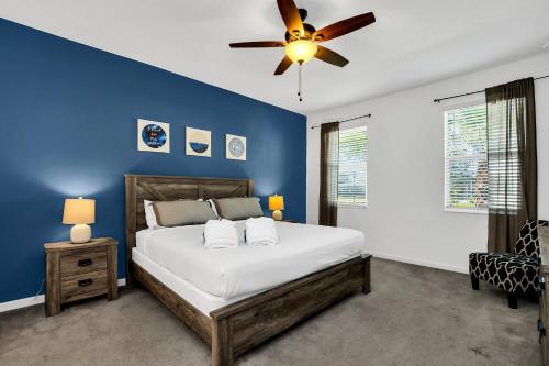 Schlafzimmer mit blauen Wänden und einem Bett mit Deckenventilator in der Unterkunft Luxury Home at Sonoma 9 En-suites SON102 in Kissimmee