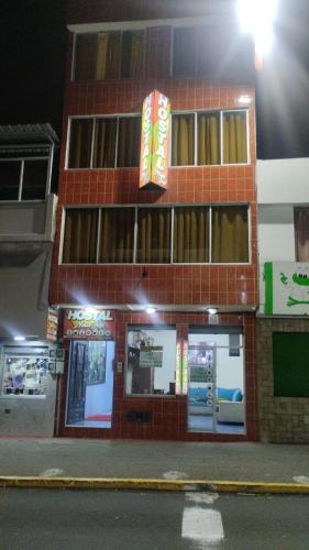un edificio di mattoni rossi con un cartello sopra di Hostal Maria José a Baños