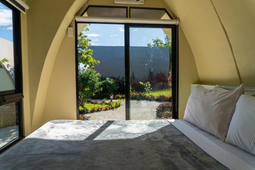 a bedroom with a bed and a large window at Tanawin BnB in Orani