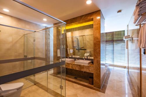 a bathroom with a glass shower and a sink at Orakai Songdo Park Hotel in Incheon