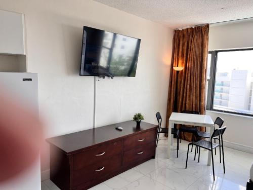 a living room with a dresser with a tv on the wall at Ocean Front Units at Miami Beach in Miami Beach