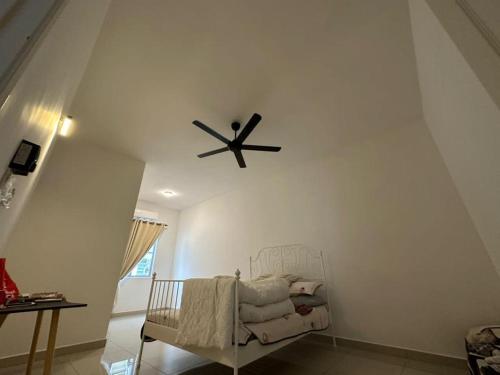 a room with a ceiling fan and a chair at DAHLIA HOMESTAY in Jitra