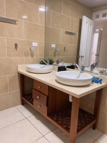 a bathroom with two sinks and a large mirror at Acogedor Apartamento remodelado in Sosúa
