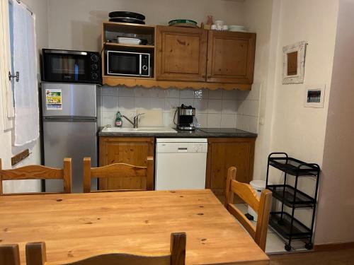 une cuisine avec une table en bois et un réfrigérateur dans l'établissement Residence le Grand Panorama - with garden & view, à Saint-Gervais-les-Bains