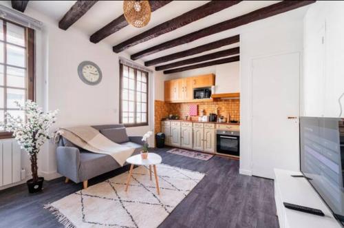 a living room with a couch and a table at Appartement 2 pièces 36m2, CDG Airport, Disneyland Paris, Asterix, Parc des expo, 10min gare de Chelles, Parking gratuit dans la ville in Le Pin