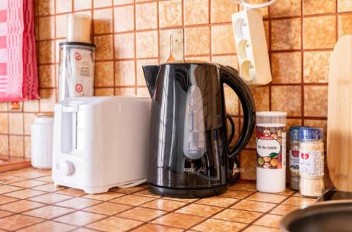 a coffee pot on a counter in a kitchen at Appartement 2 pièces 36m2, CDG Airport, Disneyland Paris, Asterix, Parc des expo, 10min gare de Chelles, Parking gratuit dans la ville in Le Pin