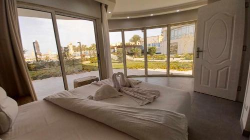 a large bed in a bedroom with a large window at Scandic resort سكانديك ريزورت in Hurghada