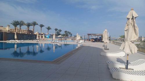 a large swimming pool with umbrellas in a resort at Scandic resort سكانديك ريزورت in Hurghada