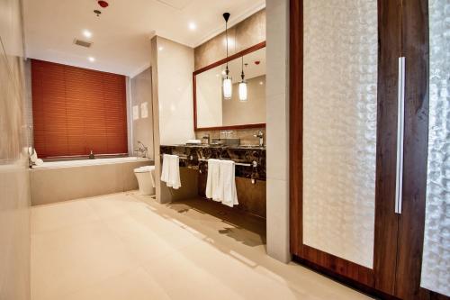 a bathroom with a toilet and a sink and a tub at Mandarin Bay Resort and Spa in Boracay